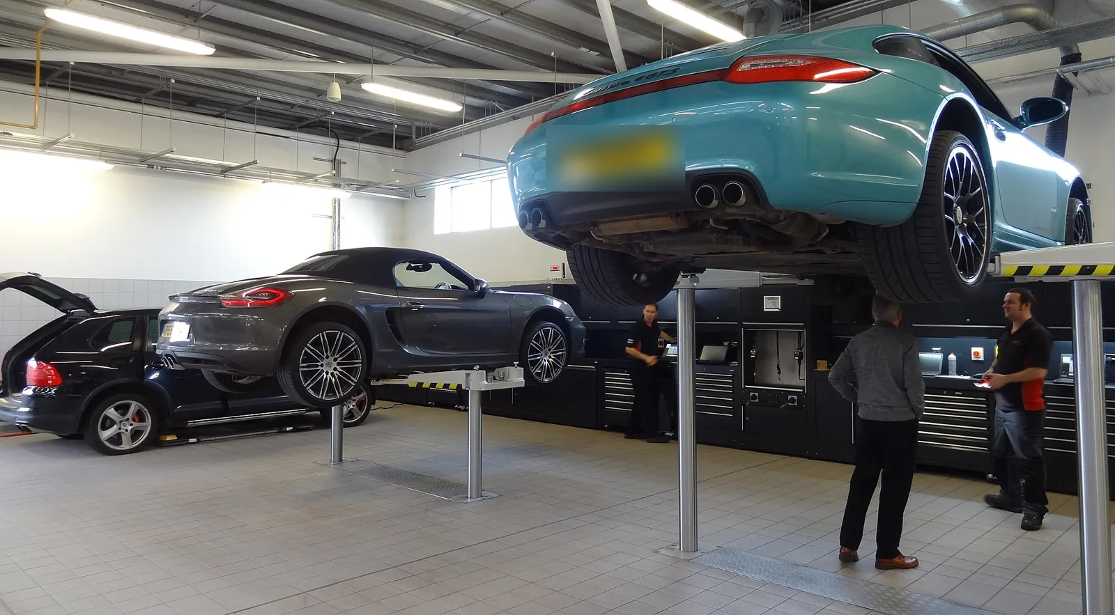 Atelier de garage : voitures de clients sur ponts élévateurs