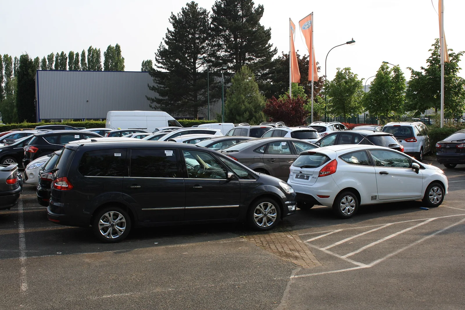 Parc de voitures d'occasion en stock devant une concession